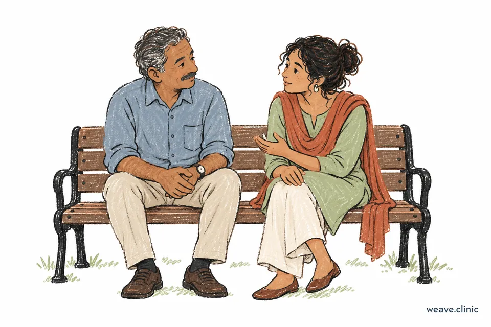 Two people sitting side by side on a bench, one speaking and the other listening