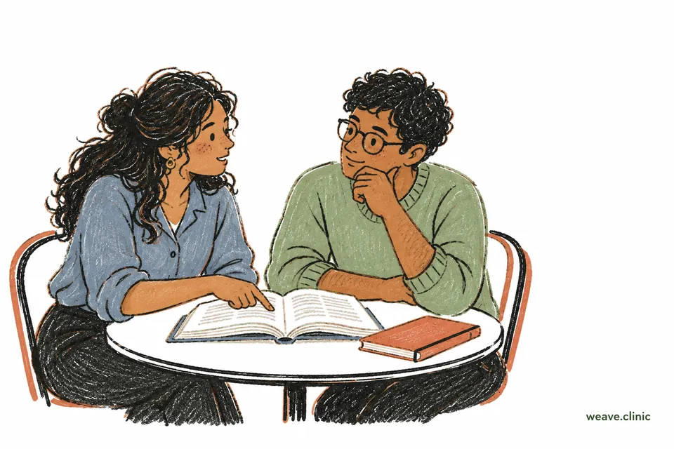 Two clinicians discussing an open reference book together